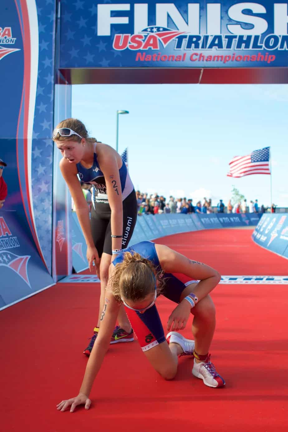 Triathletes cross the finish line after a grueling race.